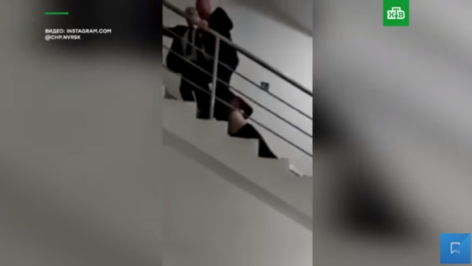 Двое мужчин в костюмах вверх по лестнице тащат в свою комнату лежащую девочку / Фото: кадр из видео 