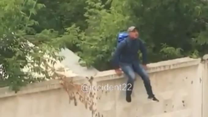 Парень в Барнауле залез на бетонный забор и предлагал купить наркотики / Фото: кадр из видео