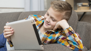 Мальчик смотрит мультфильм на планшете / Фото: freepik.com