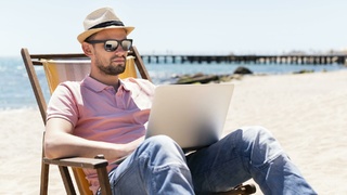 Мужчина работает на пляже / Фото: freepik