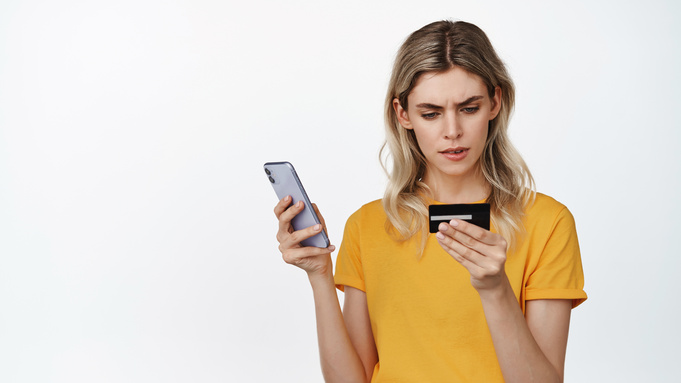 Девушка с телефоном и банковской картой / Фото: freepik.com / cookie_studio